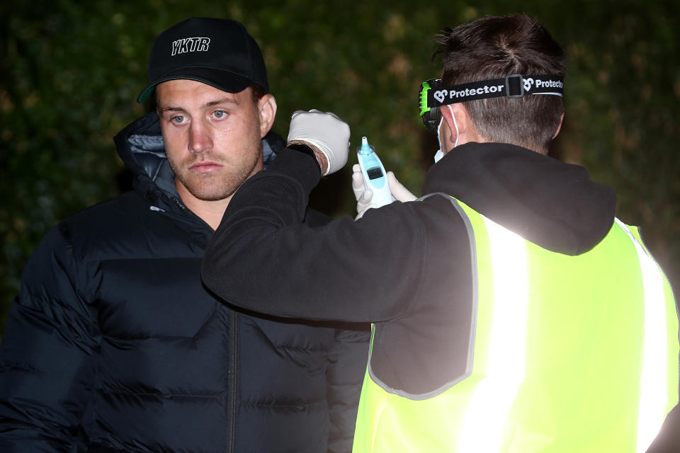 Cameron Munster is pictured having his temperature checked upon arrival at an Albury hotel.