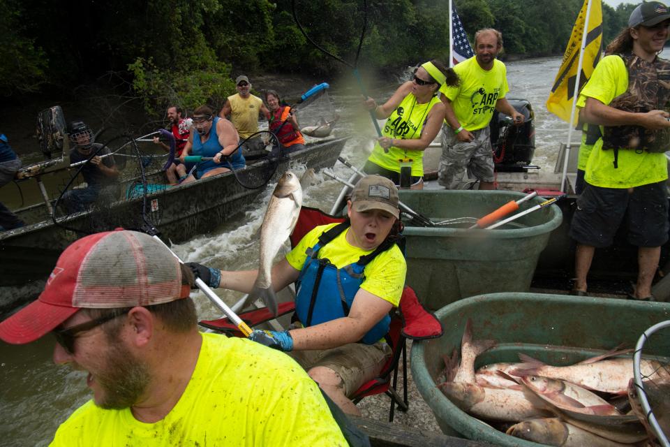 Jaxon Carney, 12, of New Haven, Ill., is unceremoniously greeted by a silver carp to the face at the Redneck Fishing Rodeo in Bath, Ill., Friday, Aug. 6, 2021. Carney's team, Team Carp Storm, were 4-time consecutive champions of the carp catching event before a two-year hiatus due to floods one year and COVID the next. 