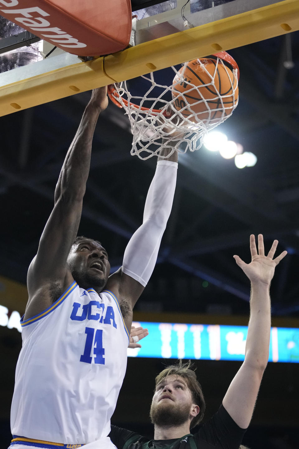 UCLA forward Kenneth Nwuba (14) dunks over Sacramento State center Callum McRae during the second half of an NCAA college basketball game Monday, Nov. 7, 2022, in Los Angeles. (AP Photo/Marcio Jose Sanchez)