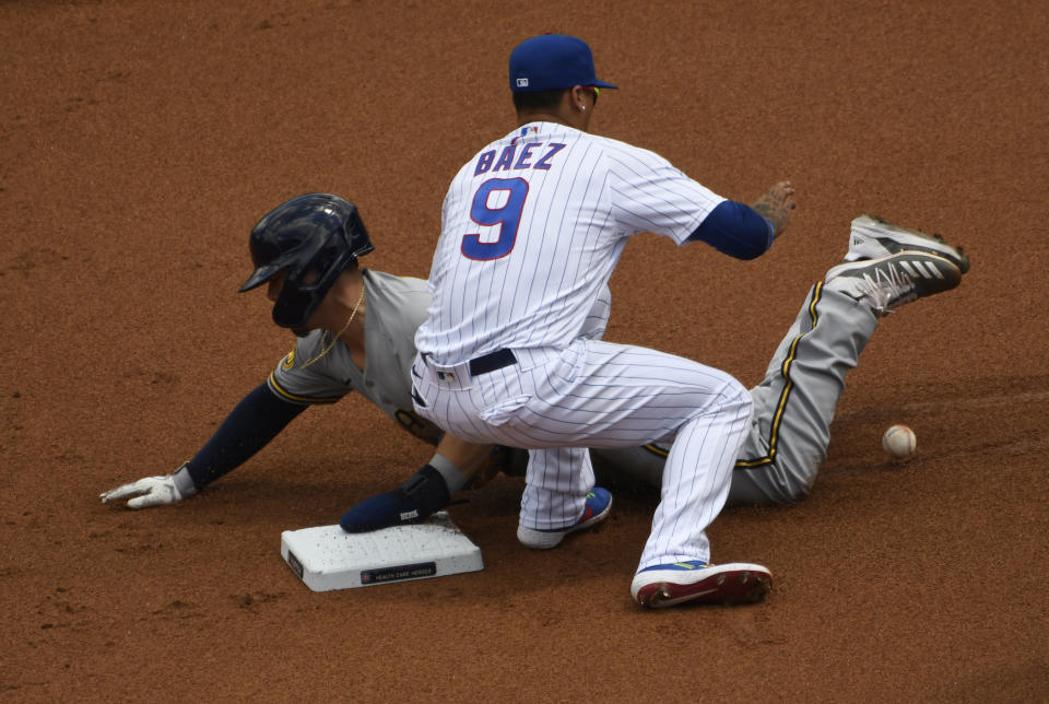 Milwaukee Brewers' Keston Hiura, left, steals second base as Chicago Cubs shortstop Javier Baez (9) takes the throw during the first inning of a baseball game Sunday, July, 26, 2020, in Chicago. (AP Photo/David Banks)