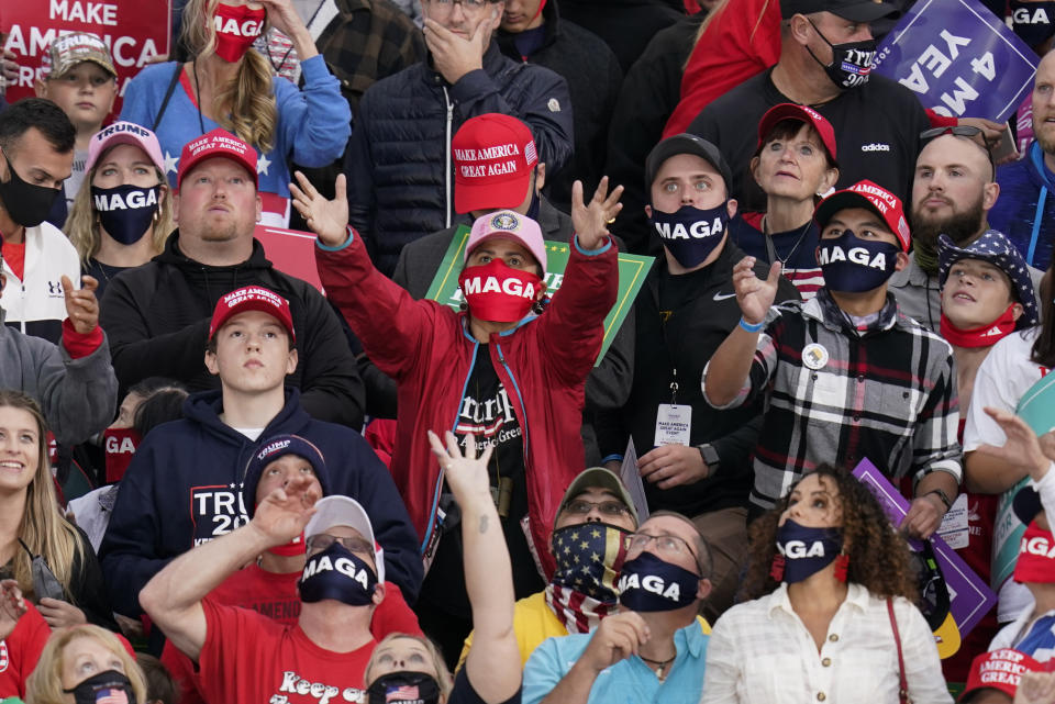 A supporter catches a hat before President Donald Trump's arrival an airport rally, Wednesday, Oct. 14, 2020, in Des Moines, Iowa. (AP Photo/Charlie Neibergall)