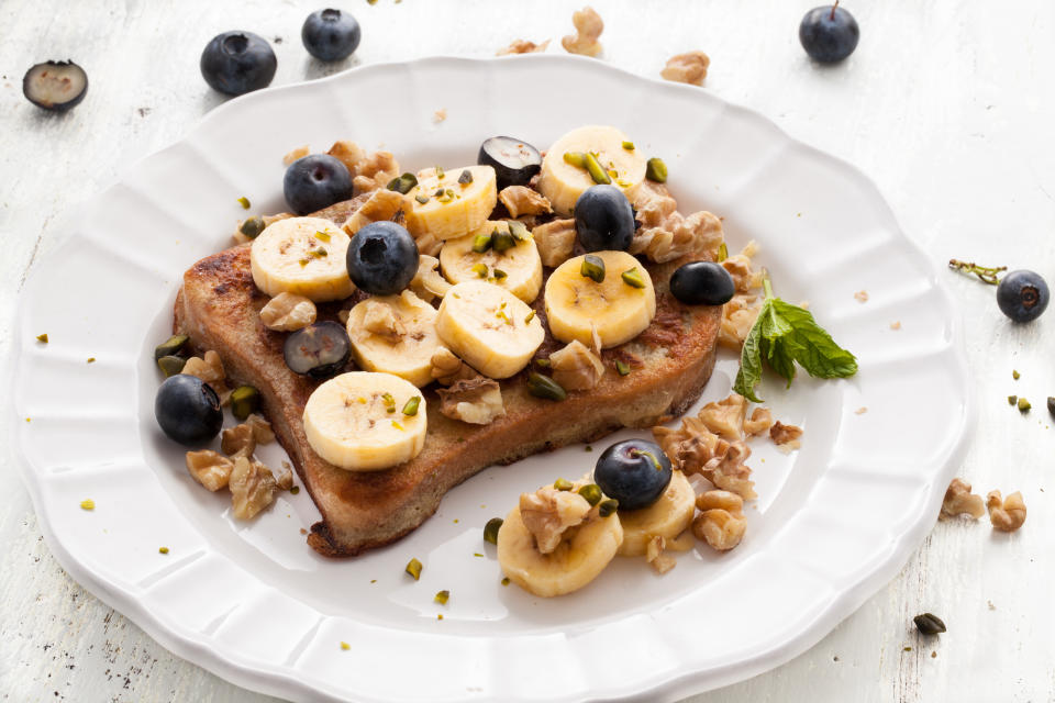 Low angle of French Toast with bananas on white wooden board