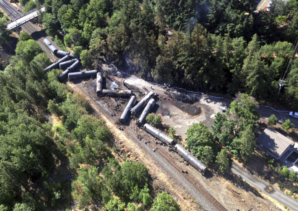 FILE - This June 4, 2016 file photo provided by the Washington State Department of Ecology, shows scattered and burned oil tank cars after a train derailed and burned near Mosier, Ore. The Trump administration is withdrawing a proposal for freight trains to have at least two crew members that was drafted in response to explosions of crude oil trains in the U.S. and Canada. Transportation officials said Thursday, May 23, 2019 that a review of accident data did not support the notion that having one crew member is less safe than a multi-person crew. (Washington Department of Ecology via AP, File)