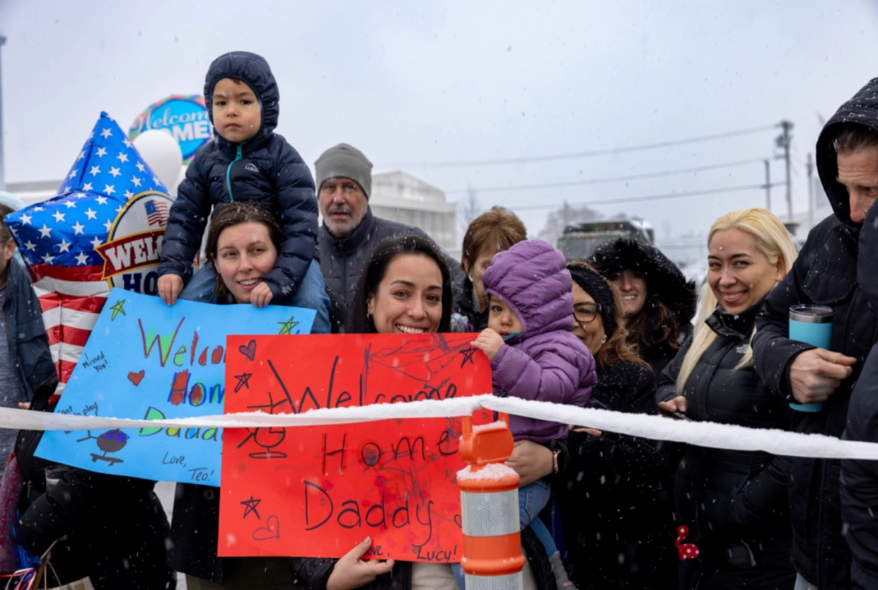Family members wait to greet their loved ones at Quonset on Saturday, Feb. 17, as more than 100 soldiers of the 1st Battalion, 126th Aviation Regiment, Rhode Island National Guard, returned home from service in Kosovo.