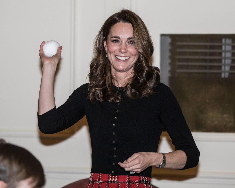 Kate jokingly gets ready to join a snowball fight (well, with fake snow!) during a <a href="https://people.com/royals/kate-middleton-prince-william-christmas-party-military-families-every-photo/" rel="nofollow noopener" target="_blank" data-ylk="slk:Christmas party held at Kensington Palace for military families;elm:context_link;itc:0;sec:content-canvas" class="link ">Christmas party held at Kensington Palace for military families</a> in December 2018.