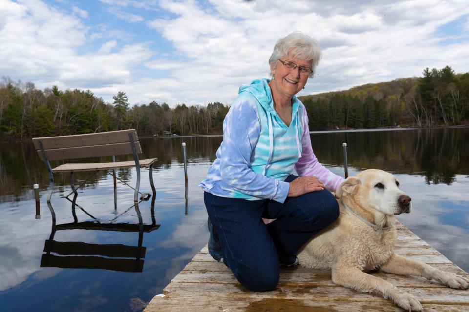 Patricia Voermans with her dog, Tucker, on her dock at her home on Lake Buteau in Gleason, Wis. Voermans says broadband always seems just out of reach. "I'm still waiting," she said, after a Frontier Communications technician came to install service, only to discover that it wasn't possible over the copper telephone lines leading to her house.