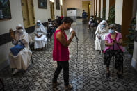 A woman sings for people who have just been inoculated with the Cuban Abdala COVID-19 vaccine as they wait in the observation area in Havana, Cuba, Wednesday, June 23, 2021. (AP Photo/Ramon Espinosa)