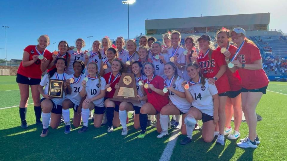 The Flower Mound Marcus girls soccer team poses with hardware after winning the Class 6A state championship 2-0 over Missouri City Ridge Point on Saturday, April 15, 2023 at Birkelbach Field in Georgetown, Texas.