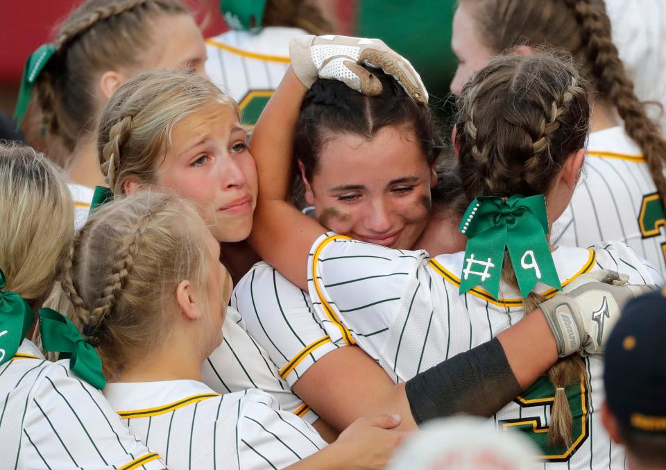 Freedom's Rylie Murphy is embraced by teammates after scoring the game-winning run against New London during their WIAA Division 2 state semifinal softball game Friday at Goodman Diamond in Madison. Freedom won 11-10.