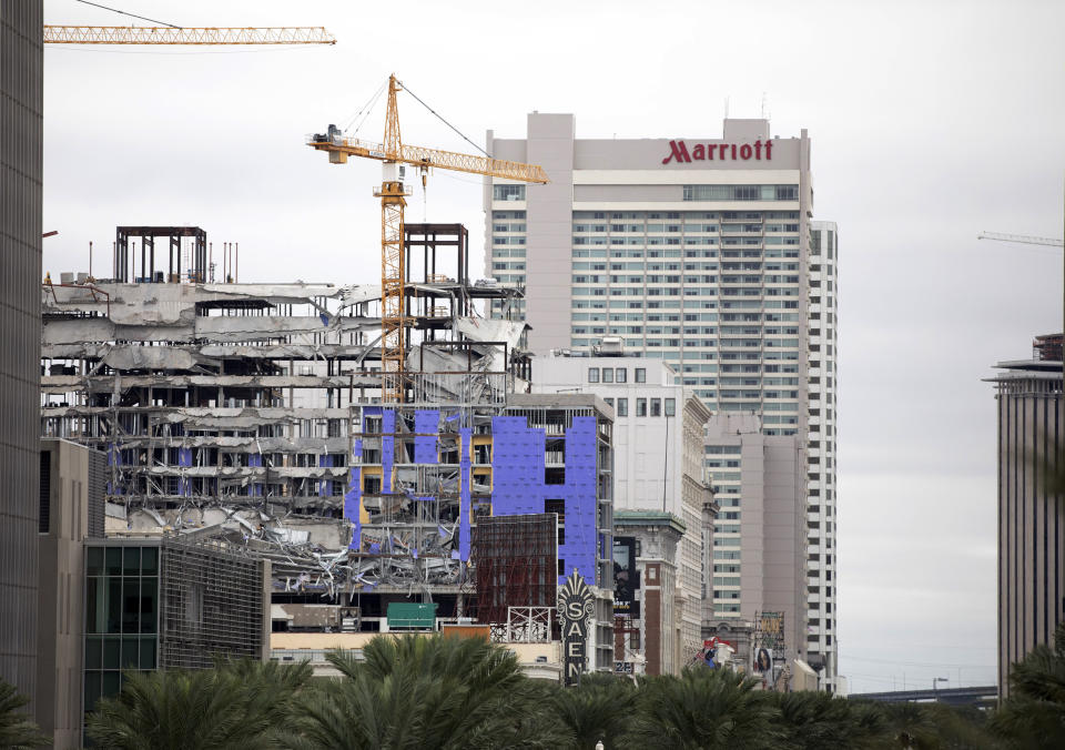 Debris hangs on the side of the building after a large portion of a hotel under construction suddenly collapsed in New Orleans on Saturday, Oct. 12, 2019. Several construction workers had to run to safety as the Hard Rock Hotel, which has been under construction for the last several months, came crashing down. It was not immediately clear what caused the collapse or if anyone was injured. (David Grunfeld/The Advocate via AP)