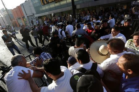 Teachers charge and break a police barricade during a protest against President Enrique Pena Nieto's education reform, in Monterrey, Mexico July 6, 2016. REUTERS/Daniel Becerril