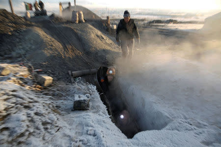 Workers enter the shaft of a primitive coal mine outside Ulaanbaatar, Mongolia January 27, 2017. The miners at the Nalaikh coal deposit, outside the Mongolian capital, go as much as 60 meters underground to mine the coal. REUTERS/B. Rentsendorj