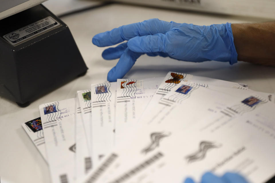 A worker processes mail-in ballots at the Bucks County Board of Elections office prior to the primary election, Wednesday, May 27, 2020 in Doylestown, Pa. (AP Photo/Matt Slocum)