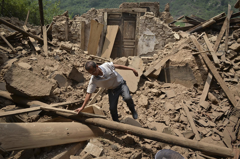 A man checks a destroyed house following an earthquake which hit Luozehe town in Yiliang county in southwest China's Yunnan province Saturday, Sept. 8, 2012. Authorities poured aid into a remote mountainous area of southwestern China and rescue workers with sniffer dogs searched for survivors Saturday after twin earthquakes killed at least 80 people. (AP Photo) CHINA OUT