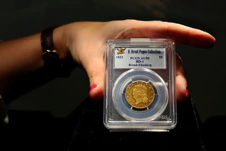 A Sotheby's employee adjusts an 1822 Half Eagle (5 dollar gold piece) which is part of the D. Brent Pogue collection to be sold on Tuesday at Sotheby's in New York, U.S., May 24, 2016. REUTERS/Lucas Jackson