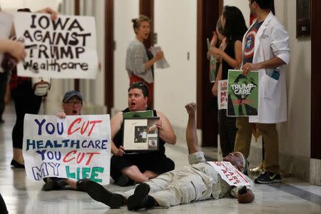 Healthcare activists are detained by Capitol Police after gathering to protest the Republican healthcare bill on Capitol Hill in Washington, July 19, 2017. REUTERS/Aaron P. Bernstein/Files