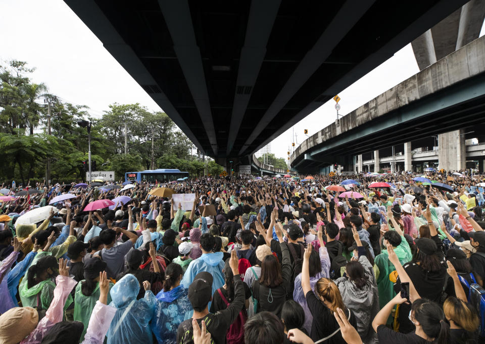 Pro-democracy protesters raise three-finger salutes, a symbol of resistance, as they gather during a protest near a main train station in Bangkok, Thailand, Saturday, Oct. 17, 2020. The authorities in Bangkok shut down mass transit systems and set up roadblocks Saturday as Thailand's capital braced for a fourth straight day of determined anti-government protests. (AP Photo/Sakchai Lalit)