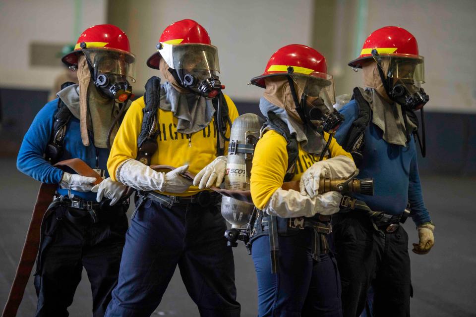 Sailors take part in a fire drill in the hangar bay during a fast cruise aboard the aircraft carrier USS Nimitz (CVN 68). The fast cruise consists of equipment tests, simulations, scenarios, which refresh and train Sailors for underway periods.