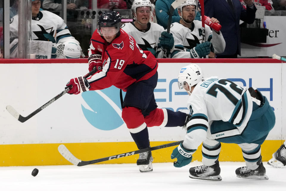 Washington Capitals center Nicklas Backstrom (19) passes the puck around San Jose Sharks center William Eklund (72) in the second period of an NHL hockey game, Sunday, Oct. 29, 2023, in Washington. (AP Photo/Mark Schiefelbein)