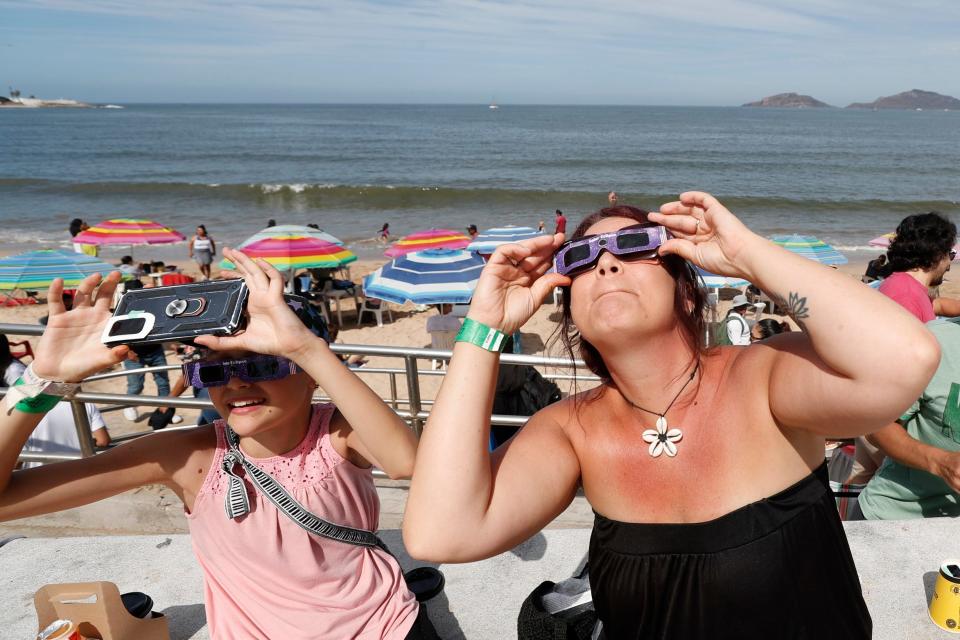 Samantha Jack and her daughter, Olivia Mykytuk, check out their eclipse glasses in preparation for the arrival of the solar eclipse in North America in the coastal city of Mazatlán in Mexico on April 8, 2024. A full solar eclipse will be visible in Mazatlán first before it moves north through Mexico and then the into the United States.