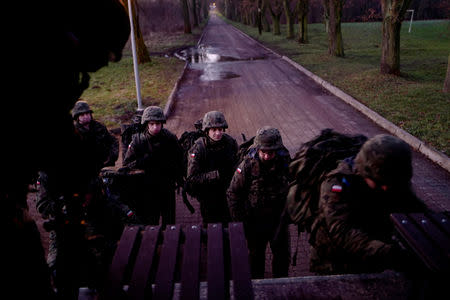 Recruits enter a truck to go on a shooting range during their 16-day basic training for Poland's Territorial Defence Forces, at a military unit in Siedlce, Poland, December 8, 2017. REUTERS/Kacper Pempel/Files