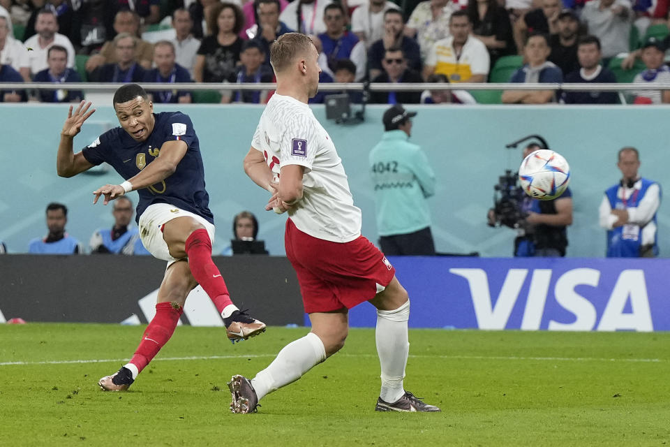 France's Kylian Mbappe, left, scores his side's second goal during the World Cup round of 16 soccer match between France and Poland, at the Al Thumama Stadium in Doha, Qatar, Sunday, Dec. 4, 2022. (AP Photo/Ricardo Mazalan)