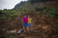 Martina Caballero, 63, stands for a portrait with her with her granddaughter, Heydi Rivera Caballero, 10, at the site of their home which was destroyed by a landslide triggered by hurricanes Eta and Iota in the village of La Reina, Honduras, Thursday, June 24, 2021. Home to about 1,000 people, the town in western Honduras was hit by two powerful hurricanes within three weeks, natural disasters made far worse by local deforestation and climate change. La Reina was buried by a landslide. (AP Photo/Rodrigo Abd)