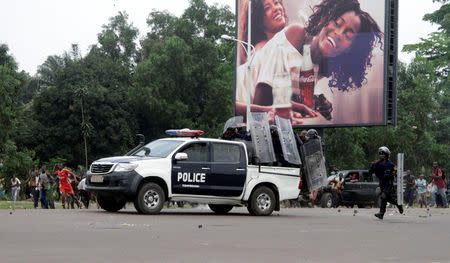 A Congolese policemen runs to their vehicle during a clash with opposition activists participating in a march to press President Joseph Kabila to step down in the Democratic Republic of Congo's capital Kinshasa, September 19, 2016. REUTERS/Kenny Katombe