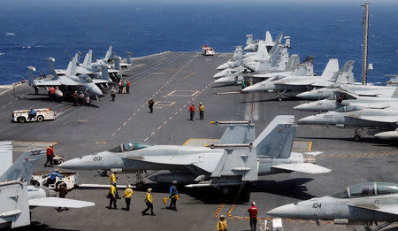 U.S. Navy personnel prepare to launch an F18 fighter jet on the deck of USS Carl Vinson in the South China Sea. REUTERS/Erik De Castro