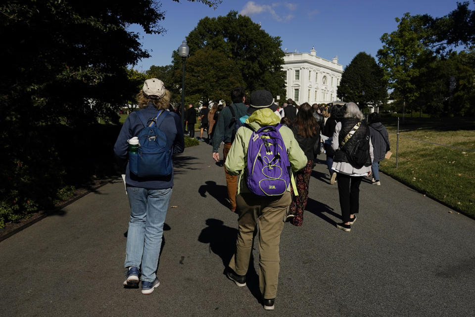 The first wave of visitors enters the South Lawn during the White House Fall Garden Tour in Washington, Saturday, Oct. 8, 2022. (AP Photo/Carolyn Kaster)