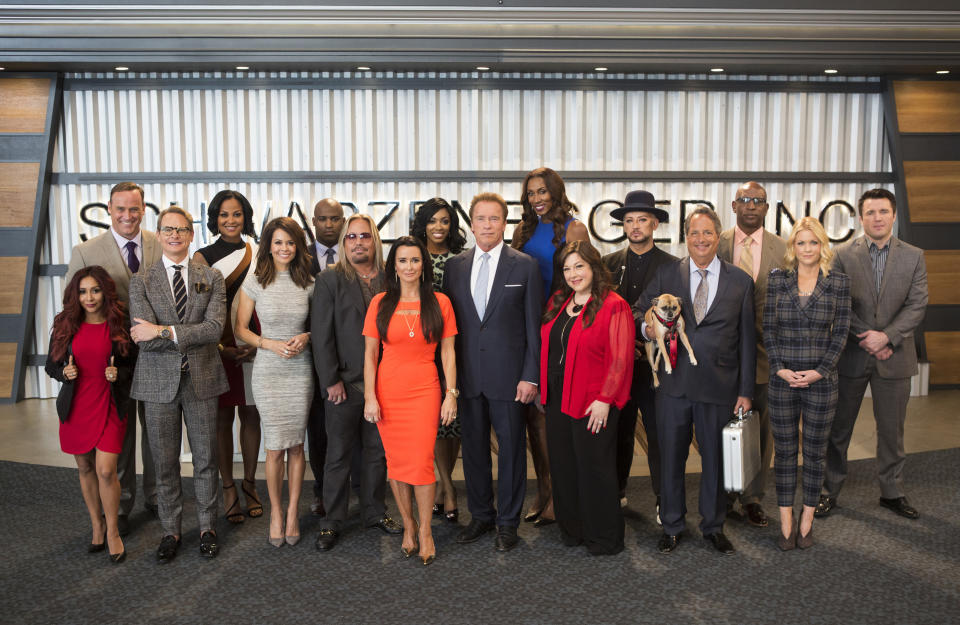 This image released by NBC shows the cast of "The New Celebrity Apprentice," back row from left, Matt Iseman, Laila Ali, Ricky Williams, Porsha Williams, Lisa Leslie, Boy George, Eric Dickerson, Chael Sonnen, and front row from left, Nicole Polizzi, Carson Kressley, Brooke Burke, Vince Neil, Kyle Richards, Arnold Schwarzenegger, Carnie Wilson, Jon Lovitz and Carrie Keagan in Los Angeles. The new season debuts Jan. 2. (Luis Trinh/NBC via AP)