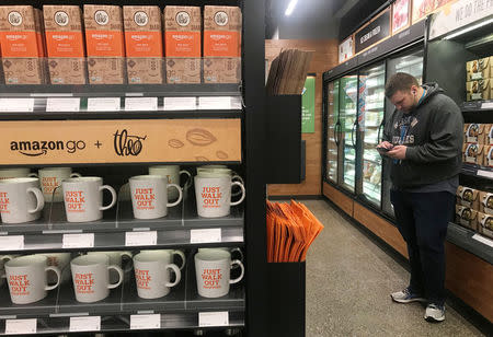 A shopper is seen using his phone in the line-free, Amazon Go store in Seattle, Washington, U.S., January 18, 2018. Photo taken January 18, 2018. REUTERS/Jeffrey Dastin