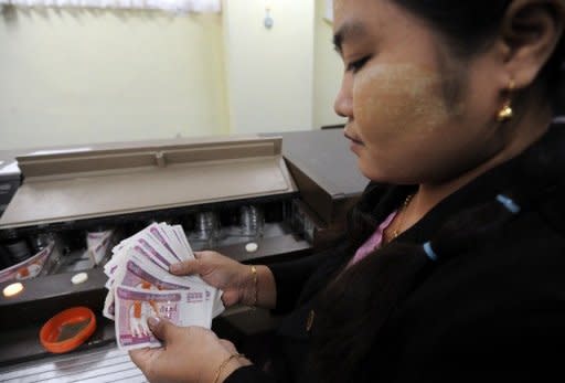 A Myanmar employee handles bank notes at the central bank in Yangon in June 2012. A US ban on all Myanmar imports is stifling key job-creating areas of the economy such as the garment industry rather than hurting the interests of the corrupt elite it targets, a report said Friday