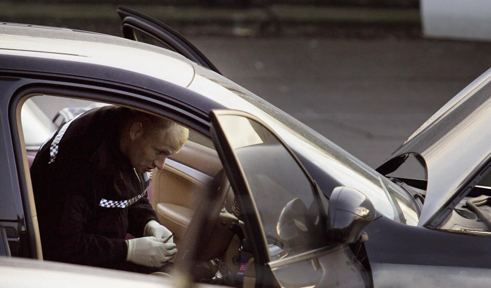 Un policía forense inspecciona uno de los automóviles usados por los atracadores para el robo. (Foto: JANE MINGAY/AFP via Getty Images)