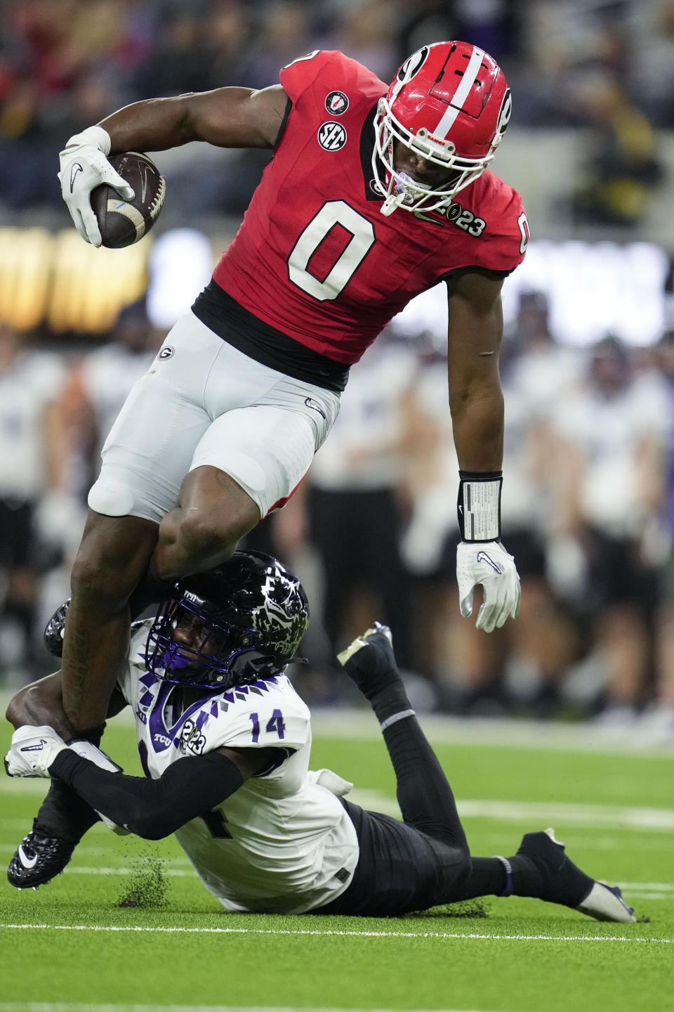 Georgia tight end Darnell Washington (0) is tripped up by TCU safety Abraham Camara (14) during the second half of the national championship NCAA College Football Playoff game, Monday, Jan. 9, 2023, in Inglewood, Calif. (AP Photo/Ashley Landis)