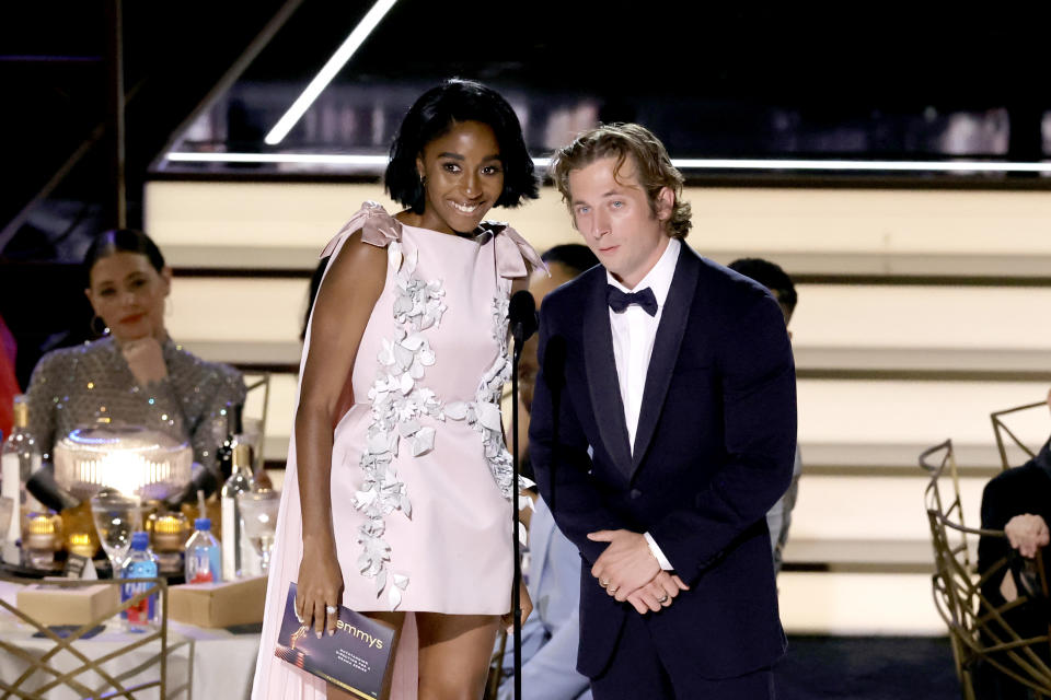 Ayo Edebiri and Jeremy Allen White on stage presenting an award at a formal event