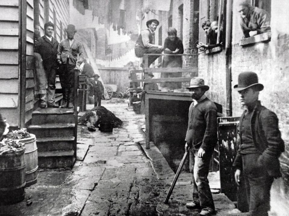 Men stand in Bandits’ Roost in New York City, circa 1890.