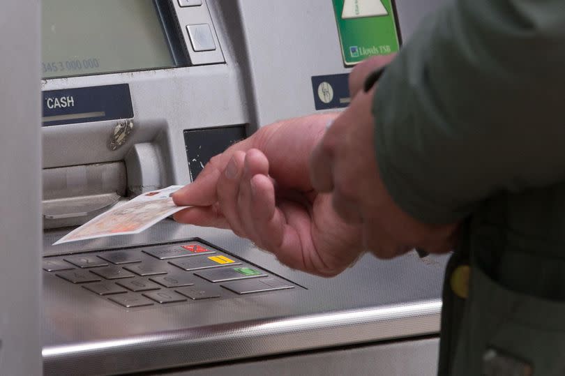 man withdrawing money from an ATM. Cash machine