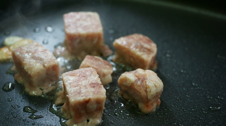 Searing flour-coated beef cubes