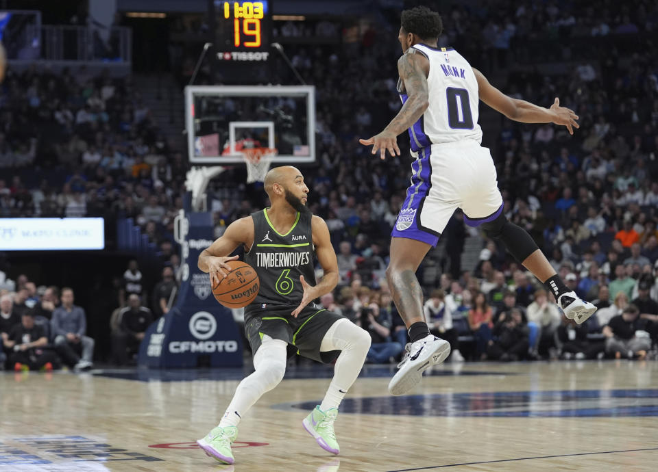 Minnesota Timberwolves guard Jordan McLaughlin (6) is defended by Sacramento Kings guard Malik Monk (0) during the first half of an NBA basketball game Friday, March 1, 2024, in Minneapolis. (AP Photo/Abbie Parr)