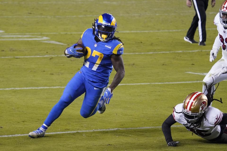 Rams running back Darrell Henderson Jr. (27) runs past the 49ers' defense.