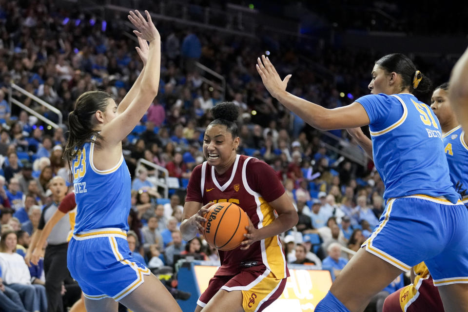 Southern California guard JuJu Watkins, center, is defended by UCLA forward Gabriela Jaquez, left, and center Lauren Betts (51) during the first half of an NCAA college basketball game Saturday, Dec. 30, 2023, in Los Angeles. (AP Photo/Marcio Jose Sanchez)