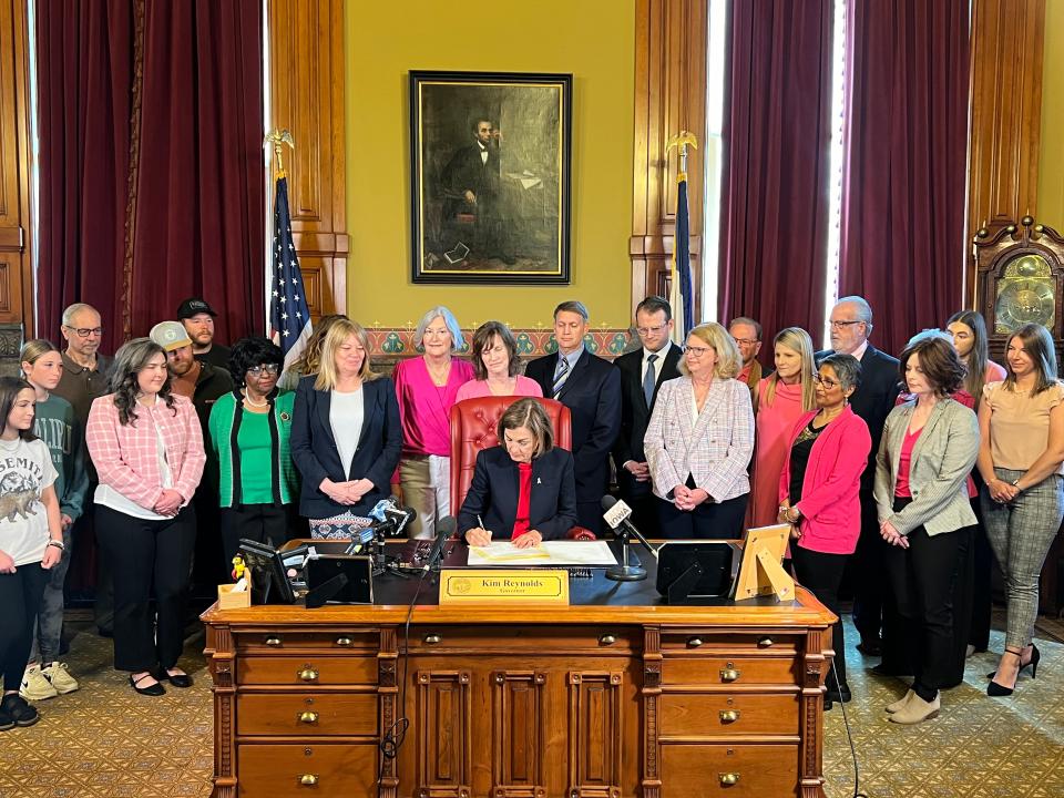 Gov. Kim Reynolds signs House File 2489 into law in her office at the Iowa State Capitol on May 1, 2024. The law requires health insurers to provide coverage for supplemental and diagnostic breast examinations.