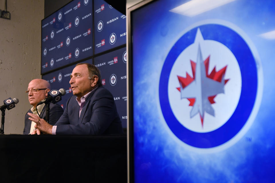 NHL Commissioner Gary Bettman, right, and Deputy Commissioner Bill Daly speak to reporters before an NHL hockey game between the St. Louis Blues and the Winnipeg Jets on Tuesday, Feb. 27, 2024, in Winnipeg, Manitoba. (Fred Greenslade/The Canadian Press via AP)