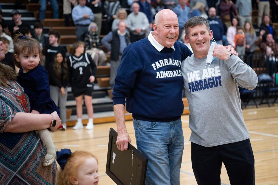 Coach Donald Dodgen, the Farragut High School athletics director, hugs Principal John Bartlett while being honored during a game in Farragut, Tenn. on Tuesday, Jan. 25, 2022. The school's gym floor was named in honor of the longtime coach.