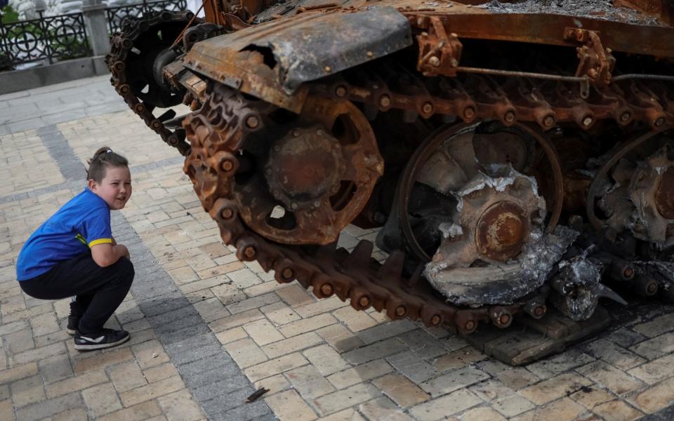 A boy looks at a destroyed Russian tank during an exhibition displaying destroyed Russian military vehicles, amid Russia's invasion, in central Kyiv -  GLEB GARANICH/ REUTERS