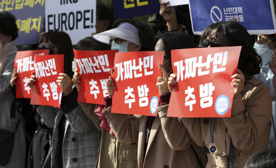 Protesters hold signs reading "deportation fake refugees" during a rally in front of the government complex in Seoul, South Korea, Thursday, Oct. 18, 2018. South Korean progressives on Thursday accused the government of caving into xenophobic sentiment by rejecting a plea for refugee status by hundreds of asylum seekers from war-ravaged Yemen whose arrival on a resort island earlier this year triggered outrage. (Kim Sun-woong/Newsis via AP)