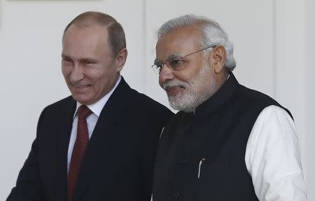 Russian President Vladimir Putin (L) and India's Prime Minister Narendra Modi arrives for a photo opportunity ahead of their meeting at Hyderabad House in New Delhi December 11, 2014. REUTERS/Adnan Abidi