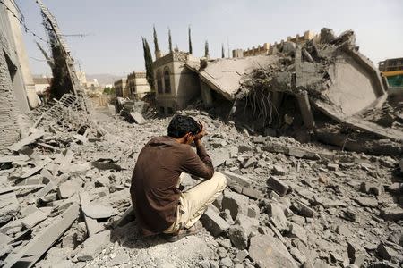 A guard sits on the rubble of the house of Brigadier Fouad al-Emad, an army commander loyal to the Houthis, after air strikes destroyed it in Sanaa, Yemen June 15, 2015. REUTERS/Khaled Abdullah