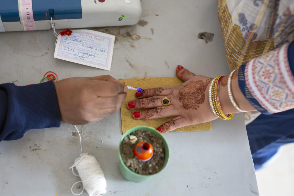 A voter gets her index finger marked before casting her ballot in a bypoll for an assembly seat in Dharmsala, India, Monday, Oct. 21, 2019. The seat was vacated by Kishan Kapoor, a Bharatiya Janata Party MLA, who was elected to the Lok Sabha in May. (AP Photo/Ashwini Bhatia)